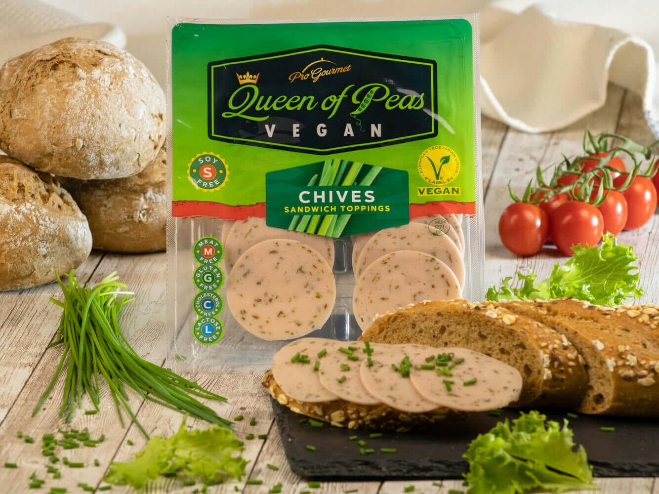 Sliced vegan chives sandwich toppings by Queen of Peas, plant-based and healthy meat alternatives on a wooden table with fresh ingredients.